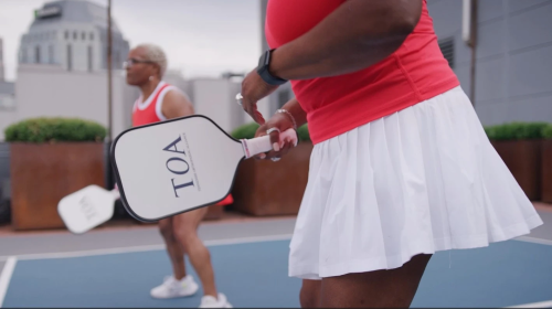 women playing tennis with TOA logo raquets